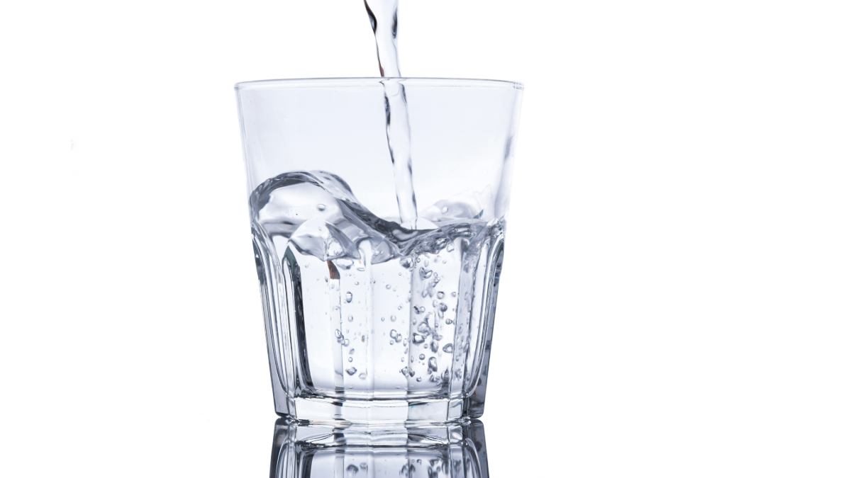 A glass of water being filled, symbolizing the practical implications of hydration for children’s cognitive performance. Cleartide in Boston offers bottleless water solutions for schools and homes.